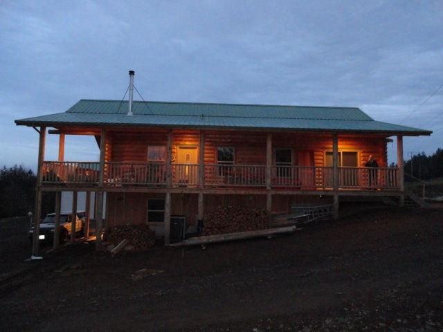 Moose Creek/Davis front of home with front lit porch built into hill with