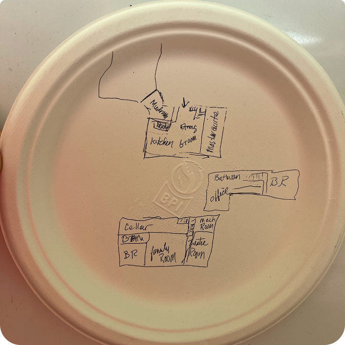 A stunning log cabin made of rich red cedar nestled among tall pine trees under a clear blue sky.