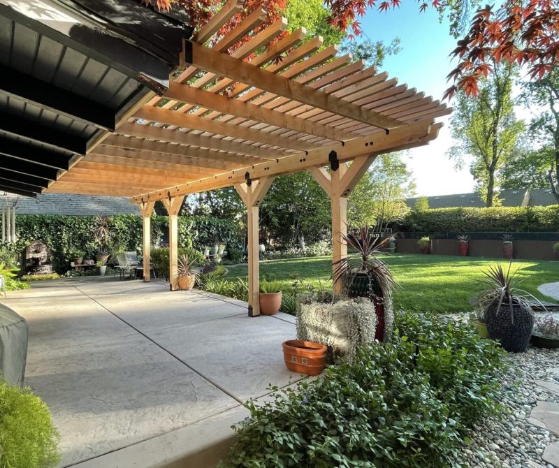A custom shade structure outdoors over a patio designed by Sierra Log & Timber